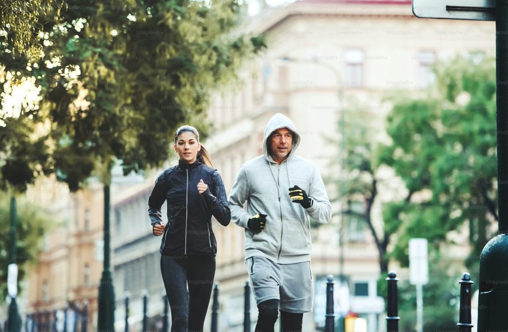 A fit sporty couple running outdoors on the streets of Prague city, Czech Republic.